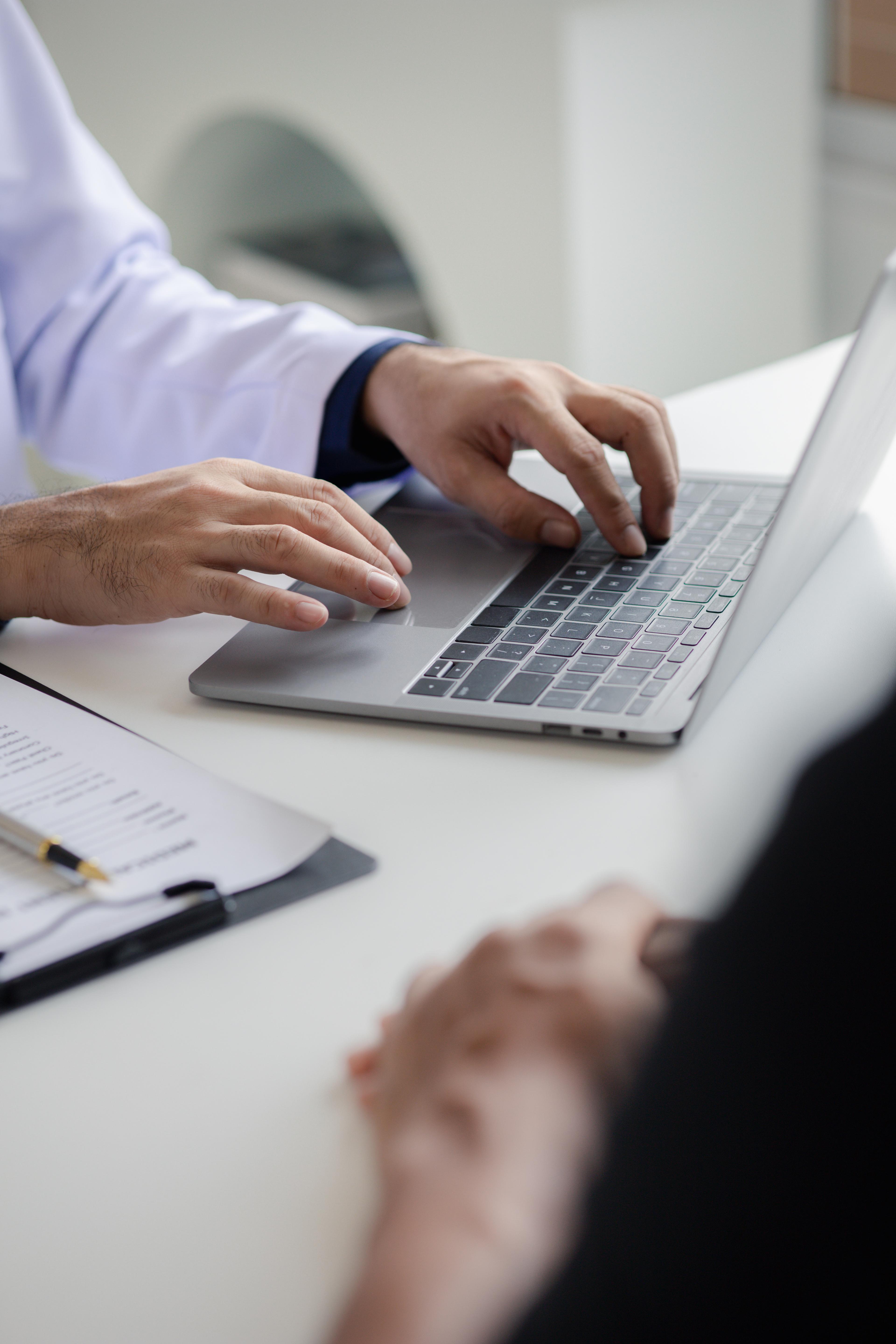 doctor typing on keyboard taking patient notes